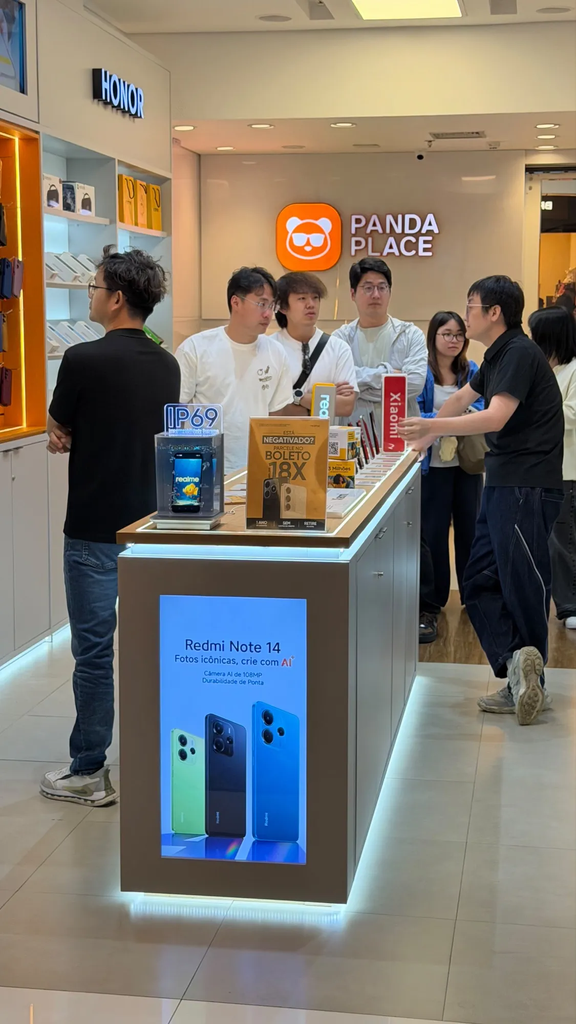 Balcão de uma loja Panda Place com smartphones expostos e clientes sendo atendidos